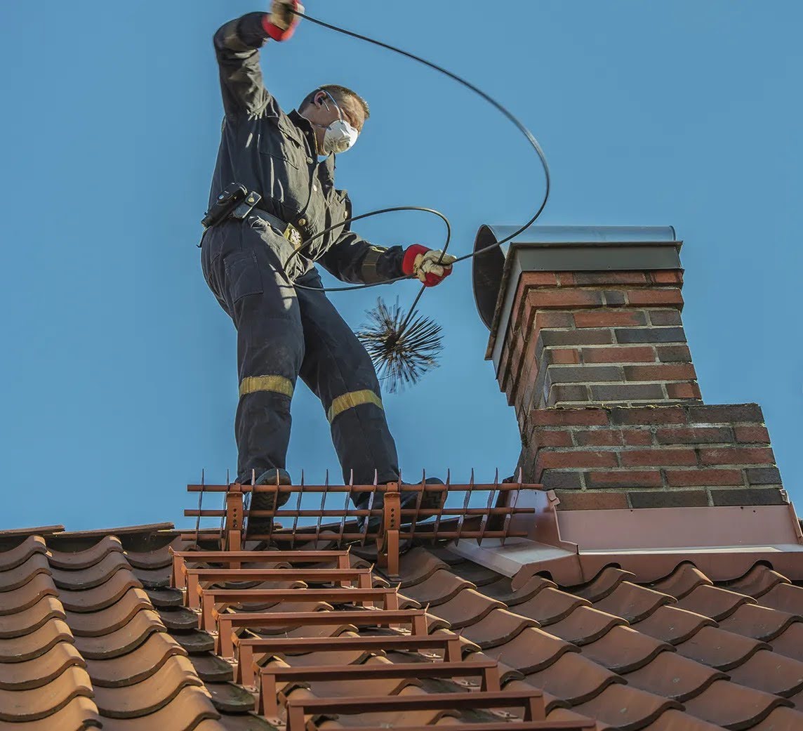 Chimney sweep working on a rooftop